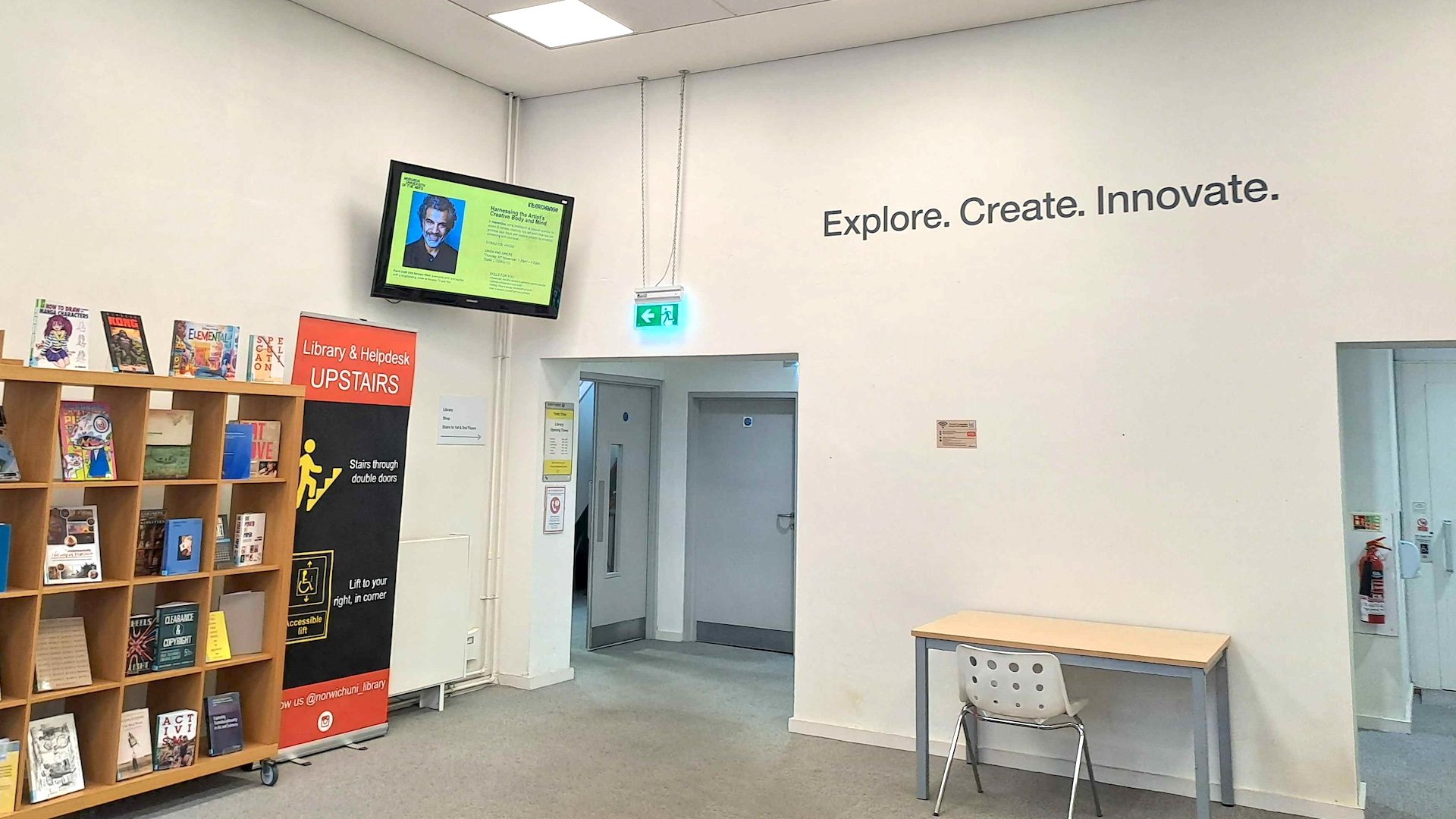 A digital signage screen in the corner of the room displaying content for the library and help desk